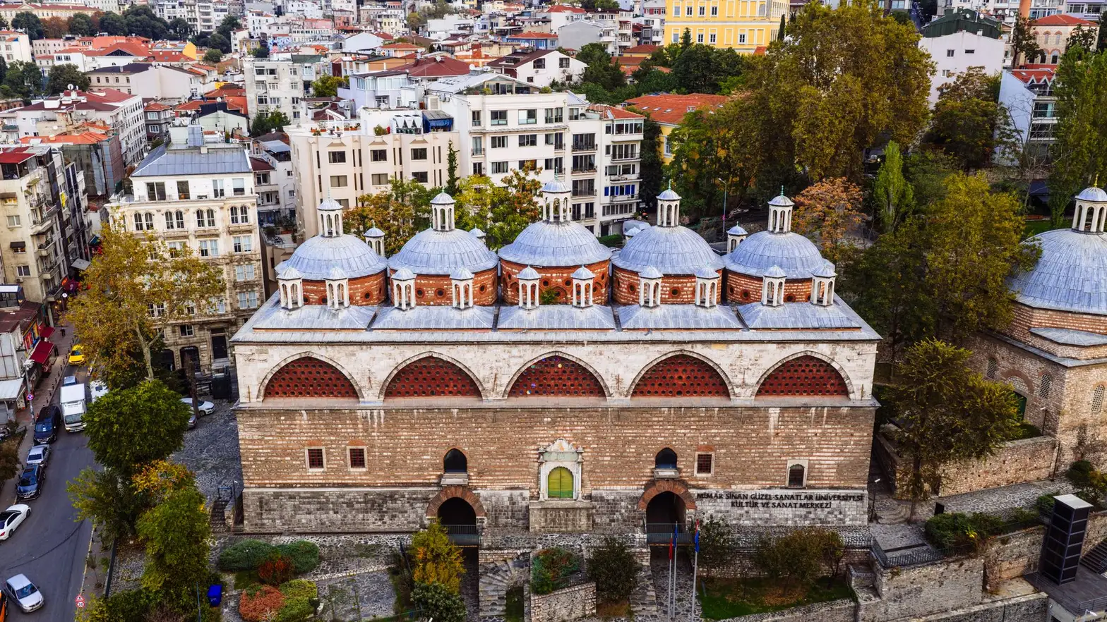 A stunning aerial view of the historic Şehzade Mosque surrounded by modern architecture in Istanbul.